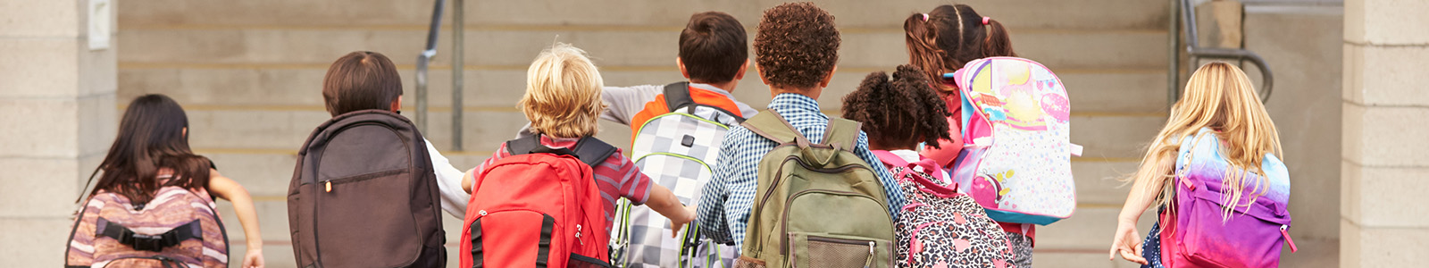 Elementary school children with backpacks on returning to school