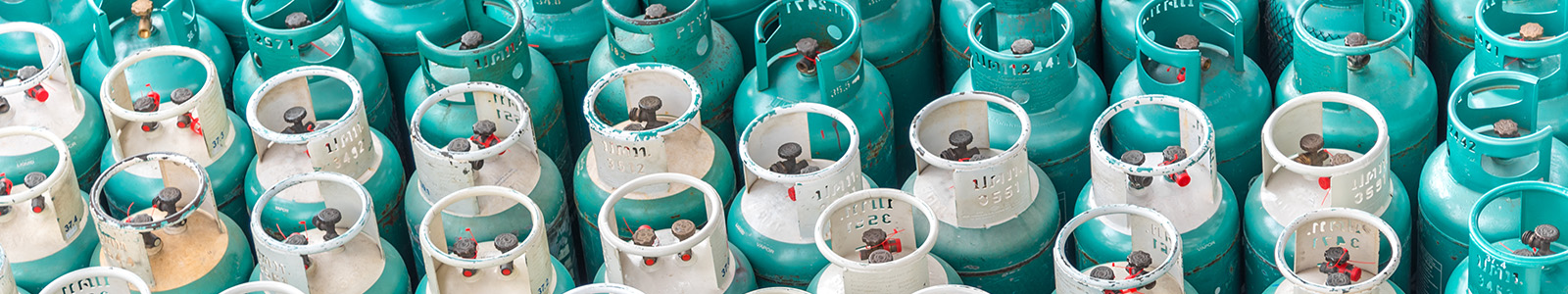 Blue and white gas cylinders stocked together