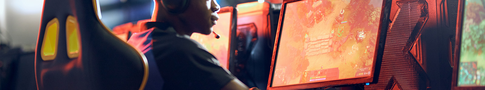 An esports gamer in an ergonomic chair in front of a PC playing video games