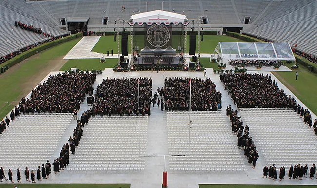 Aerial view of an outdoor graduation ceremony on a football field