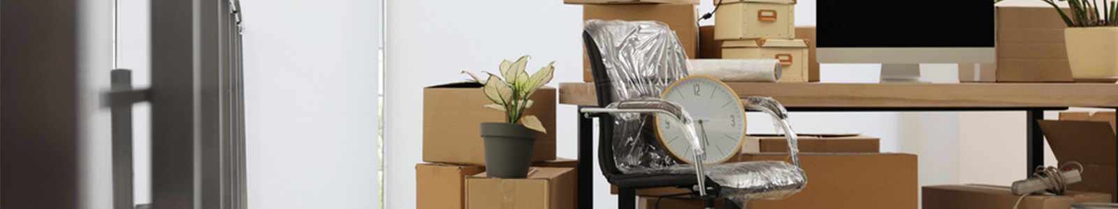 Home office being packed in cardboard boxes for employee relocation