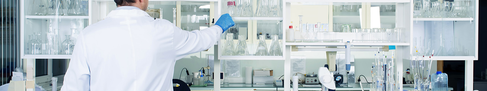 Clean modern laboratory with scientist arranging beakers