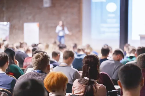 Presenter with microphone speaking before a crowd